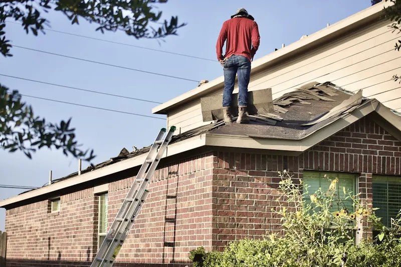 Professional roofer working on a residential roof in Rex